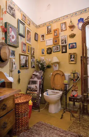 קירות השרותים והמקלחת צבועים בצבע קאמל, עליהם תלויות תמונות רבות של משפחתו וחבריו הטובים של כספין