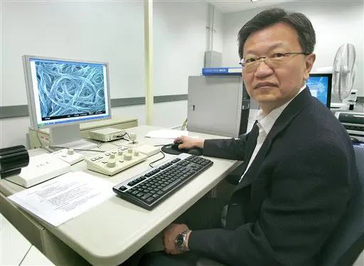 בן וואנג, ראש מחלקת פיתוח הבאקיפייפר באוניברסיטת פלורידה. ברקע, מולקולות החומר דרך המיקרוסקופ