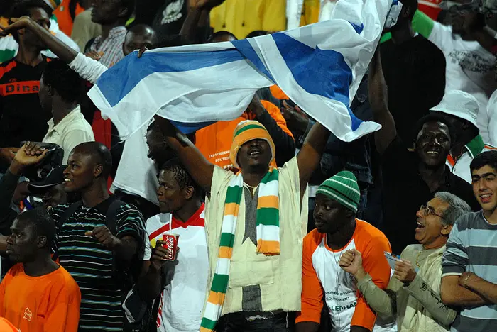 צבעו את האצטדיון האפרפר. אוהד נבחרת חוף השנהב מניף את דגל ישראל