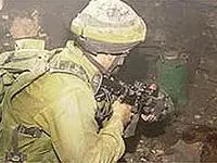 חייל סורק את ביתו של סוואלחה. השכן נכנס קודם