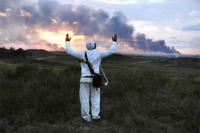 יהודי דתי נושא תפילה לשמיים על גבעה הצופה על עזה סמוך לקיבוץ ניר עם