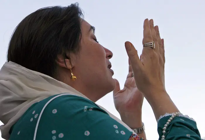 בנזיר בהוטו מתפללת עם חזרתה לקראצ'י בפקיסטן, 18 באוקטובר 2007