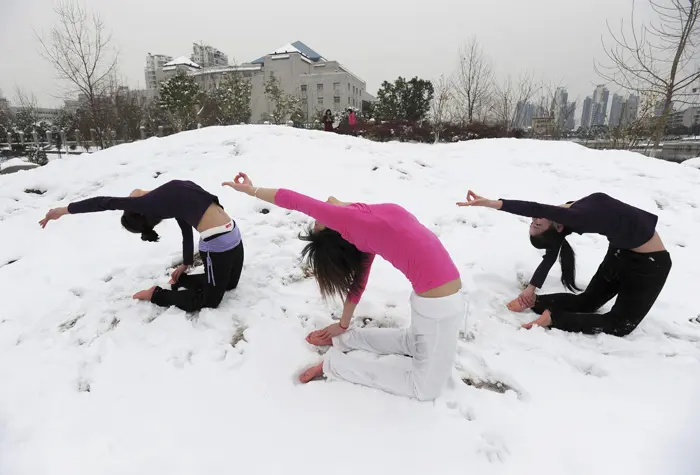 נשים סינים מתרגלות יוגה בשלג