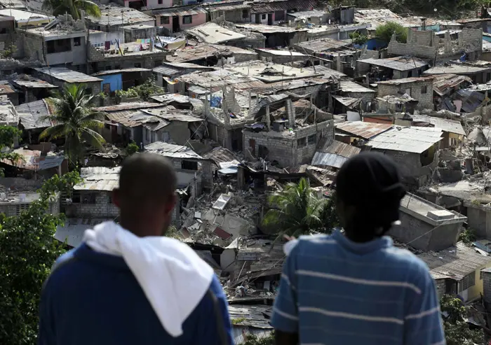 ניצולים מסתכלים על ההריסות שהותירה רעידת האדמה בהאיטי