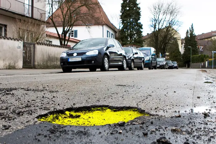 לזהות בקעים בכביש מפורר על ידי שימוש בחומר מודגש צהבהב