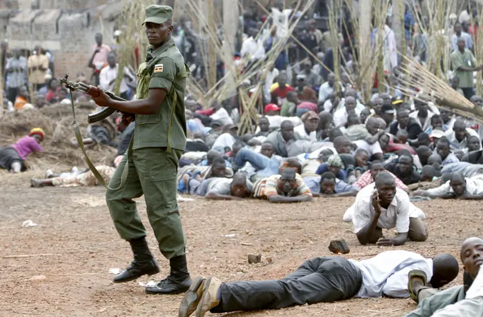 חייל באוגנדה יורה באוויר כדי למנוע הפרות סדר ליד קבר המלכים שנשרף