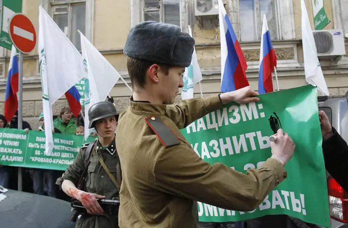 מפגינים בלבוש חיילים נאצים וסובייטי מפגינים מול שגרירות לטביה במוסקבה נגד צעדה של פרו-נאצים בריגה