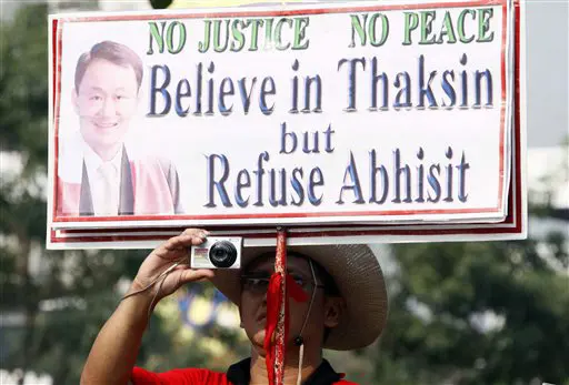 ראש הממשלה המודח טקסין קרא למפגינים לנהל מרי אזרחי. מפגין נושא שלט תמיכה בטקסין