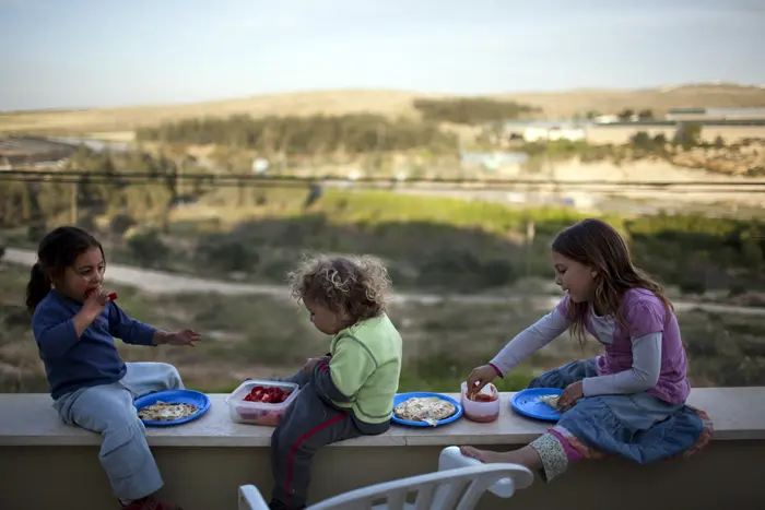 ילדי משפחת שרעבי אוכלים ארוחת ערב בחוץ, בישוב סוסיה שבדרום הר חברון