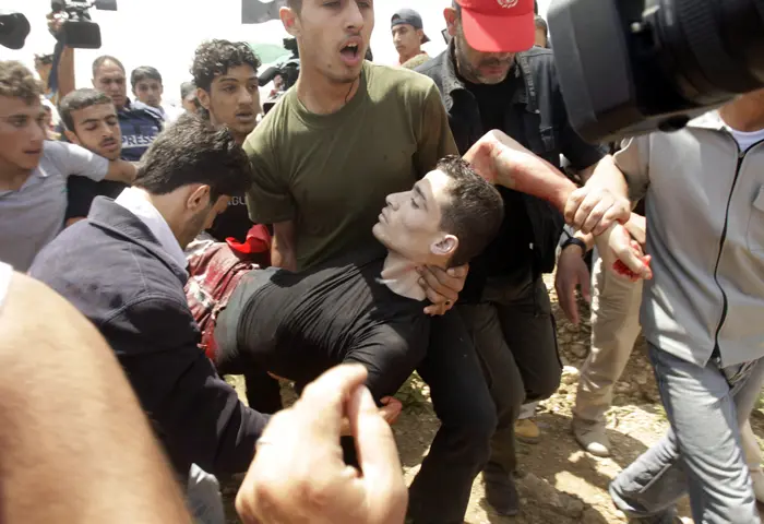 מפגינים מפנים את גופתו של אחמד דיב, פלסטיני שנורה במהלך הפגנה נגד אזור החיץ בעזה
