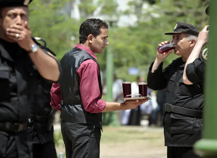 מלצר נותן מיץ לשוטרים במהלך הפגנה נגד מובארק