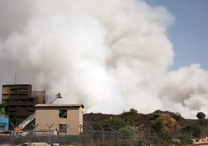 "הכבאים פועלים ביחד עם טרקטורים שהובאו למקום כדי להשתלט על האש בתוך פסולת המתכות"