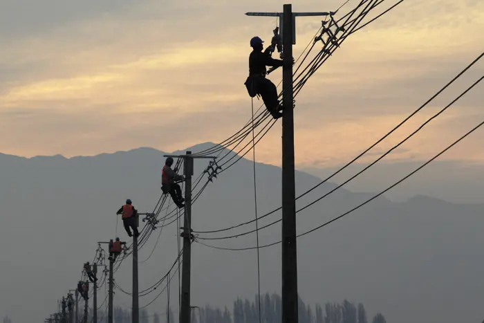 עובדים מתקנים קווי חשמל שנפגעו ברעידת האדמה בצ'ילה