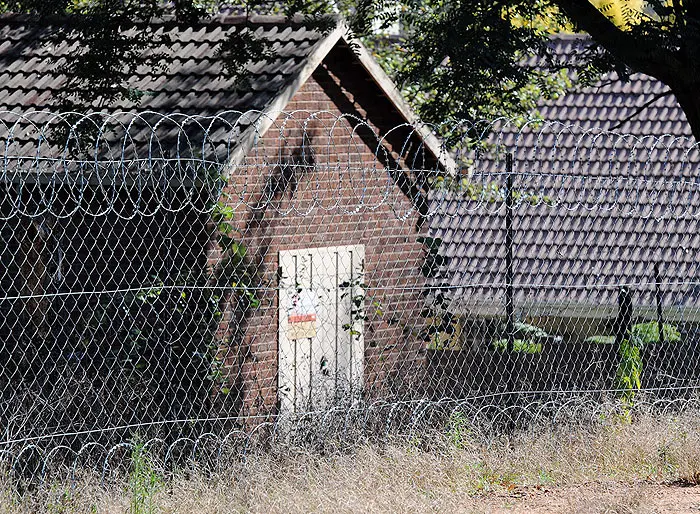 גדרות תיל מפרידות בין בתים של לבנים בדרום אפריקה