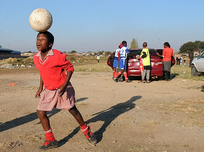 ילדה דרום אפריקאית משחק בכדורגל