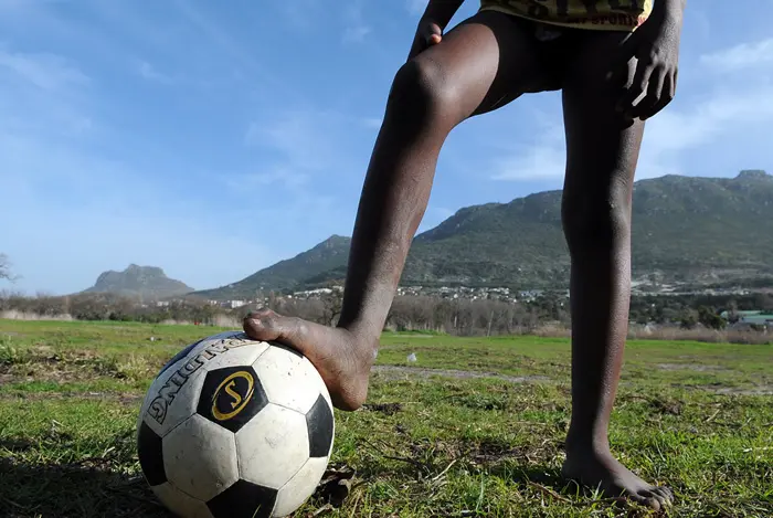 ילד דרום אפריקאי משחק כדורגל