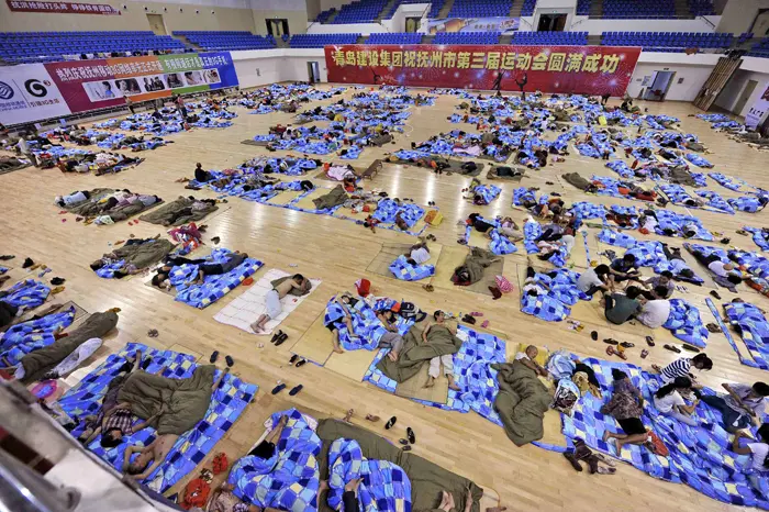 אנשים ישנים באולם ספורט לאחר שפונו מביתם עקב השיטפונות בסין