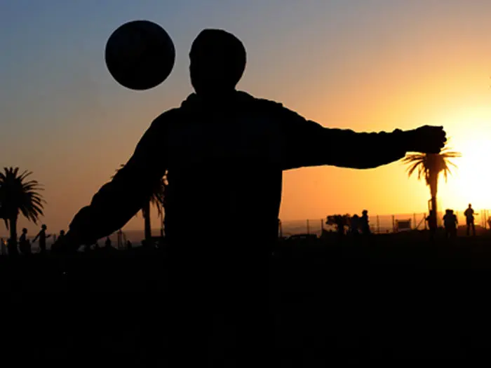 אדם משחק בכדור מול השקיעה בדרום אפריקה