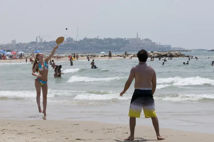 גם רחצה בים יכולה לסייע לקירור הגוף. מתרחצים בחוף תל אביב