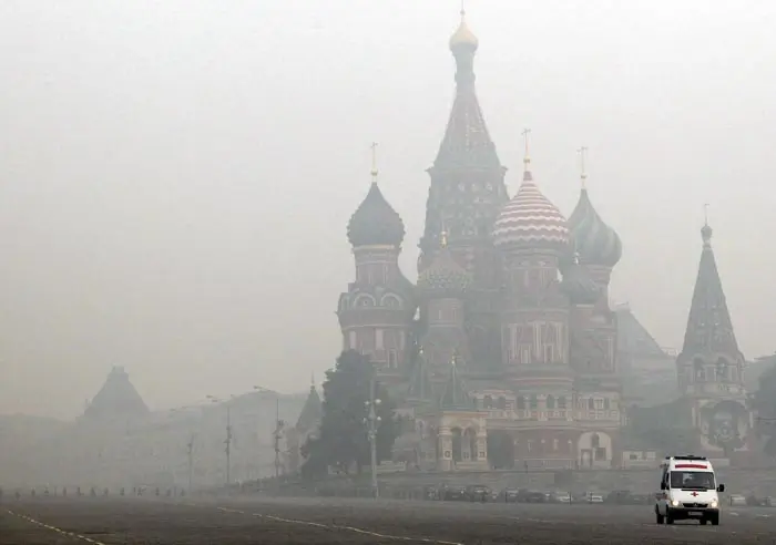 אמבולנס נוסע בכיכר האדומה במוסקבה על רקע העשן והאובך