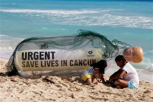 "הצילו חיים בקנקון" - כיתוב על בקבוק ענק בחוף הים של עיירת הנופש
