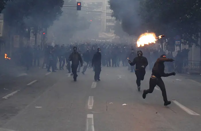 מפגינים מיידים בקבוקי תבערה לעבר כוחות המשטרה באתונה, במהלך הפגנות המוניות נגד הגזרות הכלכליות ביוון