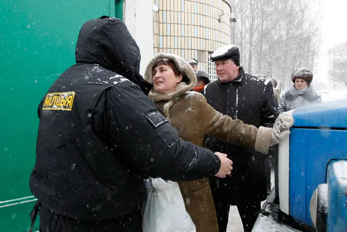אשה עוברת בידוק בטחוני בבואה לברר אודות בן משפחתה שנעצר, היום במינסק