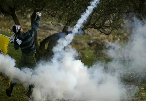 מפגינים נגד גדר ההפרדה בבילעין בתוך ענן גז מדמיע שנורה ע"י צה"ל