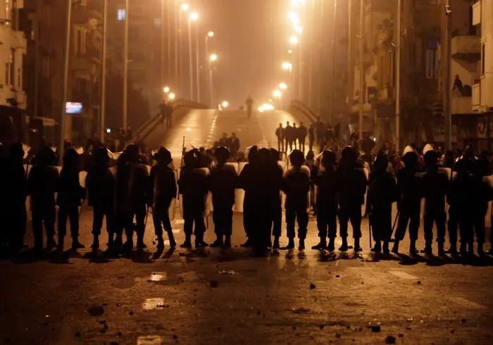 שוטרים ניצבים מול מפגינים נוצרים קופטים בקהיר