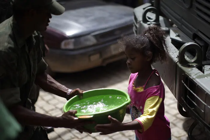 חייל מספק מים לשתייה לילדה בעיירה נובה פריבורגו במרכז ברזיל, שנפגעה קשות בשיטפונות ומפולות בוץ