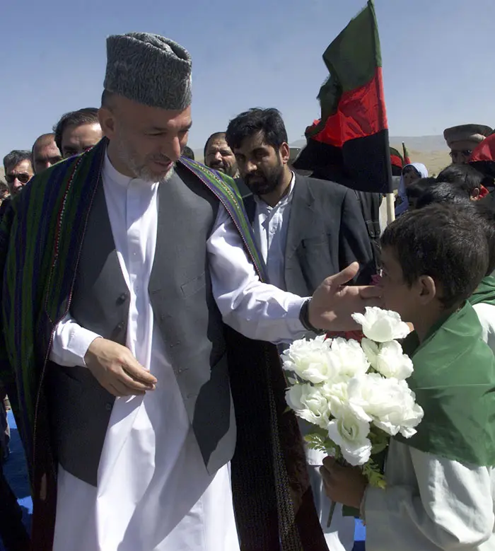 נשיא אפגניסטן, חמיד קרזאי, זוכה לברכות מילד צעיר בקאבול ב-2003