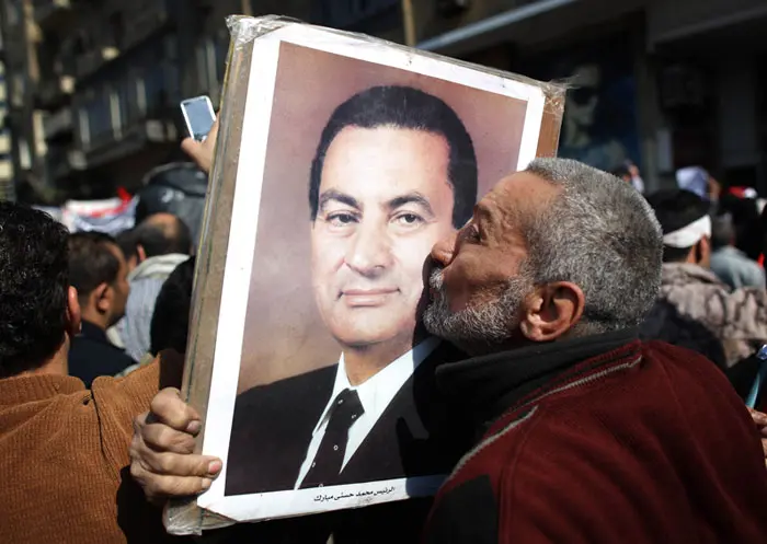 פעיל מתומכיו של מובארק מנשק את תמונתו במהלך העימותים עם מתנגדי המשטר