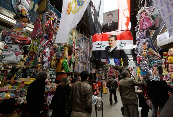 תמונה של נשיא סוריה בשאר אל-אסד בשוק בדמשק