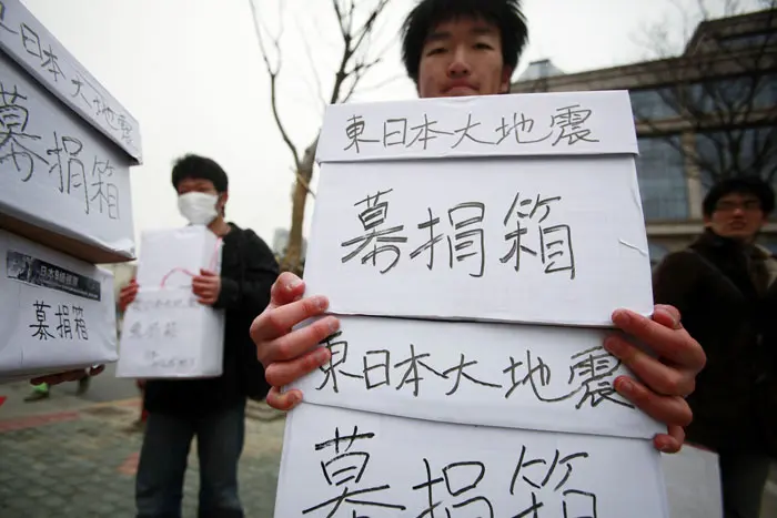 סטודנטים בטוקיו מגייסים תרומות עבור נפגעי הצונאמי שפקד את המדינה, מרץ 2011