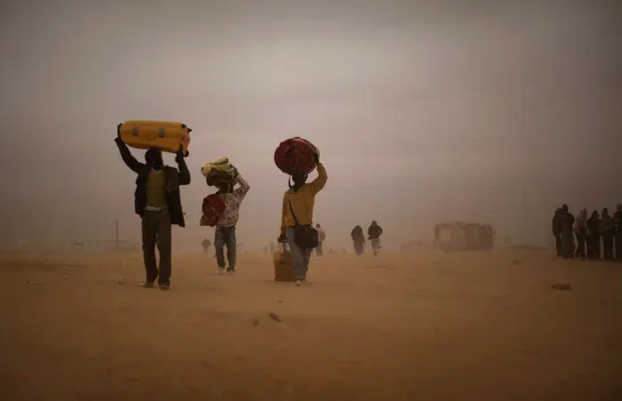 פליטים שנמלטו מלוב חולפים בסופת חול בגבול טוניסיה, 15 במרץ 2011