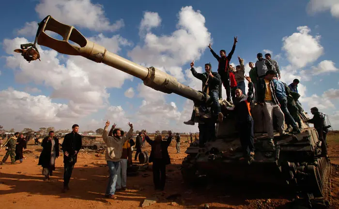 מורדים חוגגים על תותח של כוחות קדאפי שהושמד ליד אג'דבייה, 20 במרץ 2011