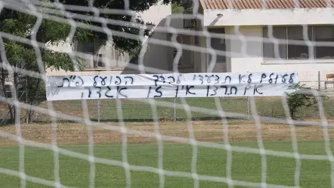 שלט של אוהדי הפועל פתח תקוה: לעולם לא תצעדי לבדך