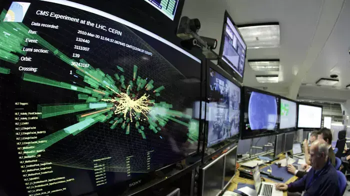 חדר הבקרה של מאיץ החלקיקים של CERN בשוויץ, כשעל המסך הדמיה של התנגשות פרוטונים, 13 בדצמבר 2011