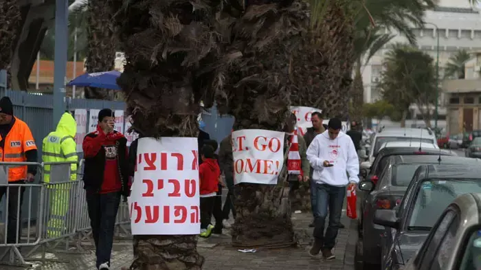 שלטי מחאה של אוהדי הפועל תל אביב נגד אלי טביב