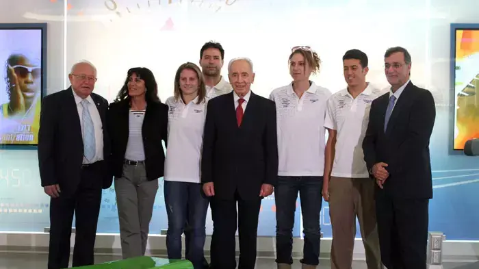 נשיא המדינה שמעון פרס יחד עם הספורטאים האולימפיים שחר צוברי, לי קורזיץ, אריק זאבי ואליס שלזינגר ועם יו"ר הוועד האולימפי צבי ורשביאק, מנכ"ל הוועד האולימפי אפרים זינגר וספורטאית בעבר אסתר רוט שחמורוב