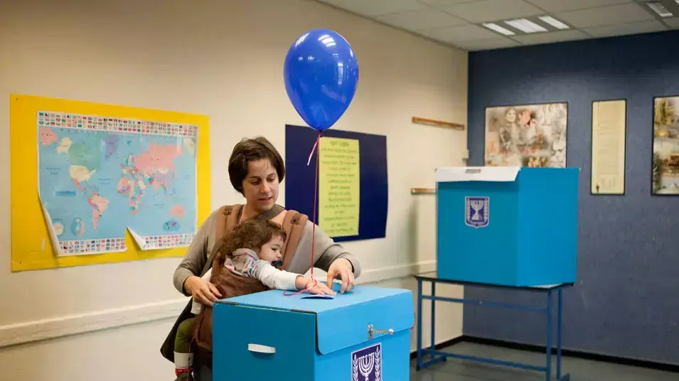 מצביעה עם בתה בקלפי בתל אביב, ינואר 2013