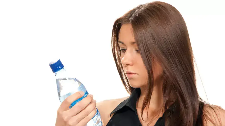 אישה עם בקבוק מים מינראליים