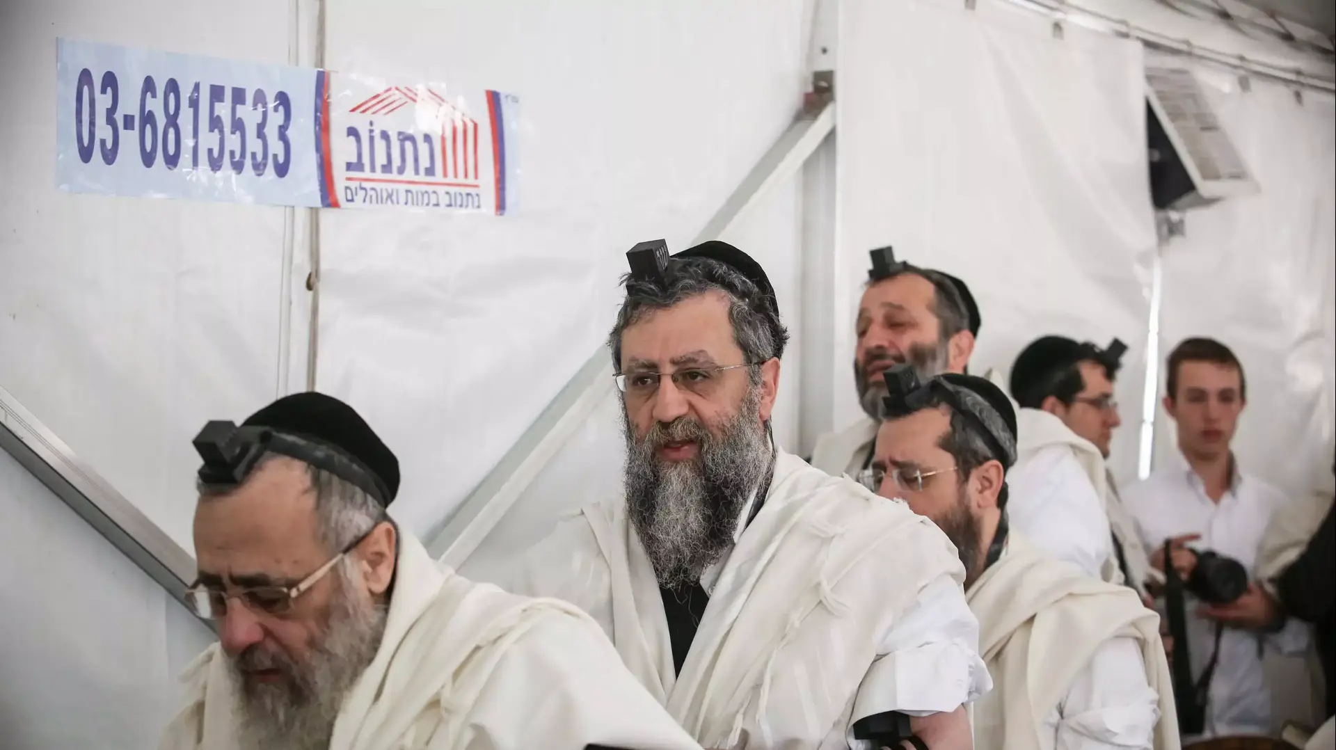מניחים תפילין בסוכת האבלים בבית משפחת  יוסף, אוקטובר 2013