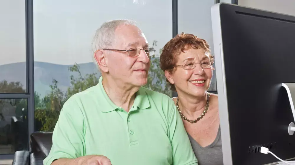 זוג מבוגרים יושבים מול מחשב