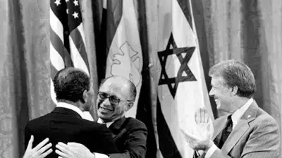 אנואר סאדאת ומנחם בגין לצד ג'ימי קרטר מתחבקים בקמפ דייויד 1978,