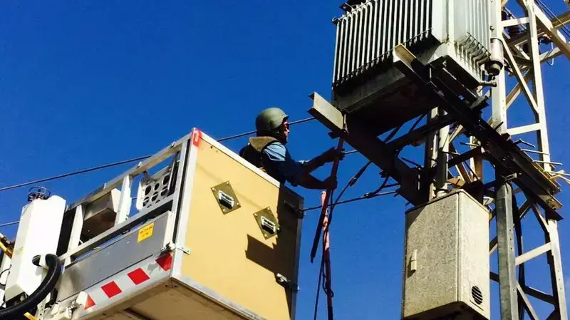 עובדי חברת החשמל מתקנים חוטים קרועים בעקבות פגיעת רקטה בעוטף עזה, יולי 2014