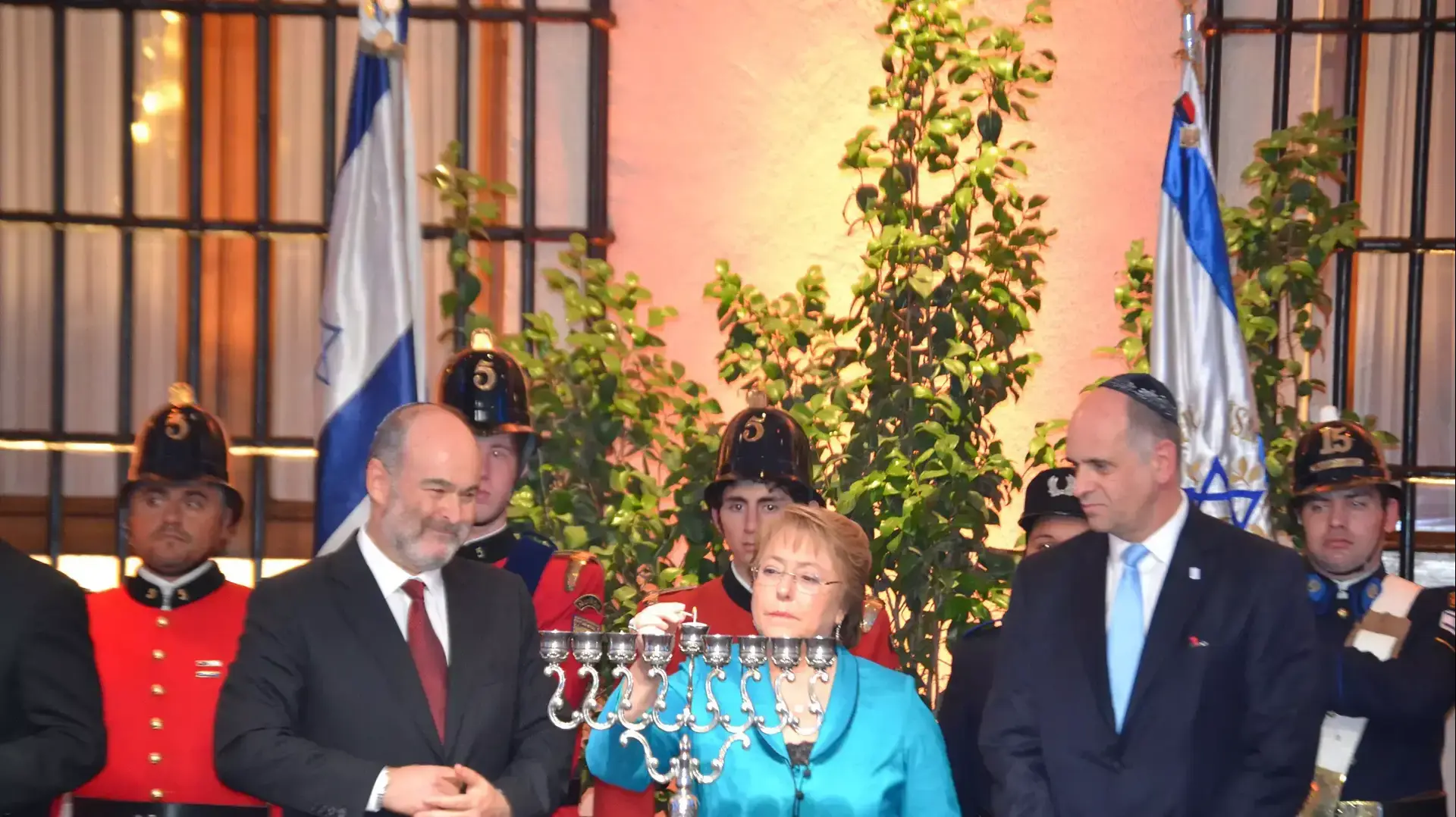 "נשיאת צ'ילה  מישל באשלה מדליקה נרות יחד עם ראש הקהילה היהודית והשגריר רפאל אלדד"
