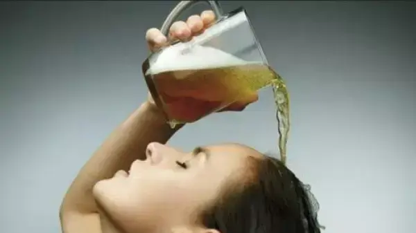 אישה שוטפת את השיער עם בירה
