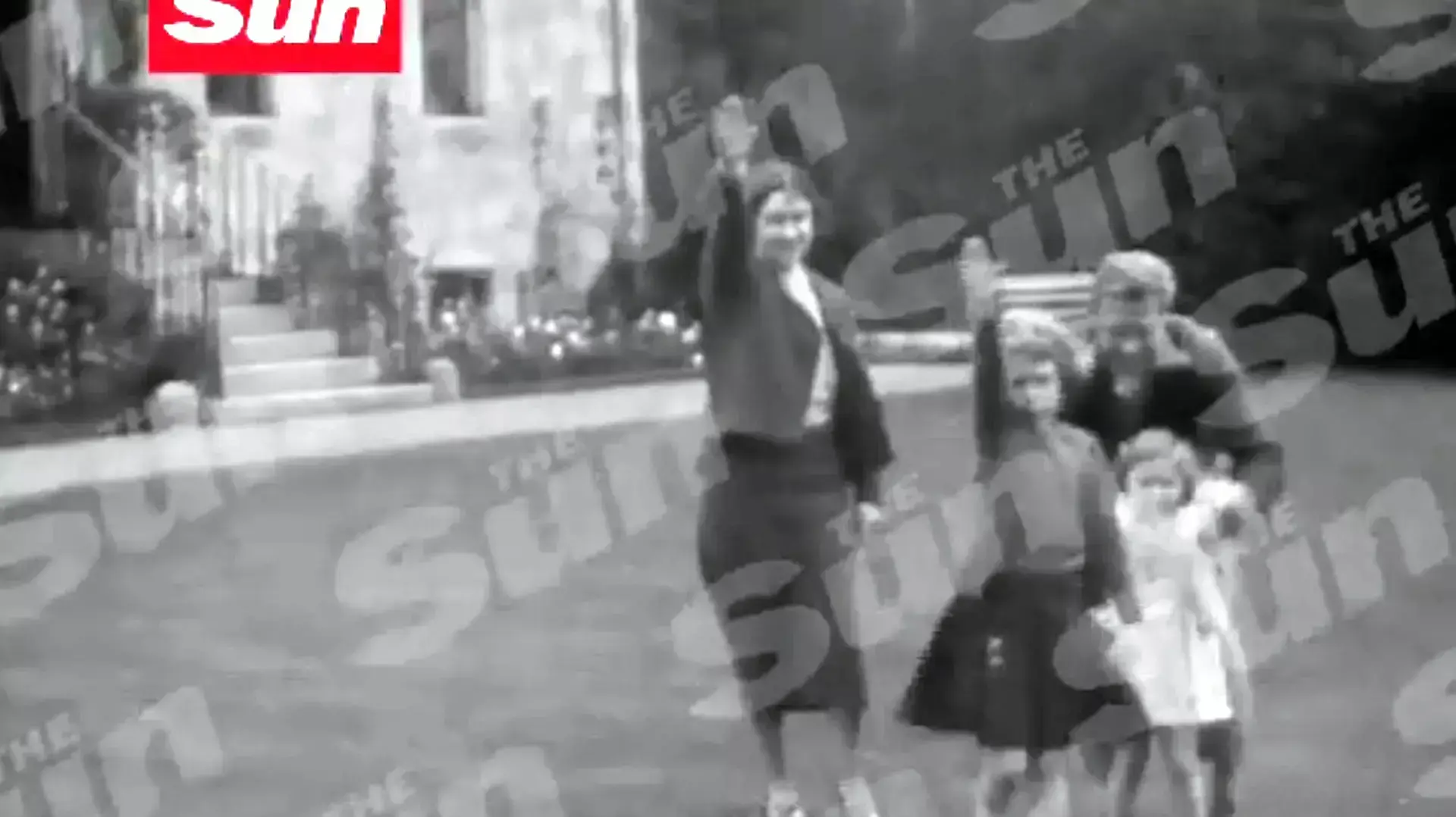 המלכה אליזבת והמלכה האם נראות מצדיעות במועל יד