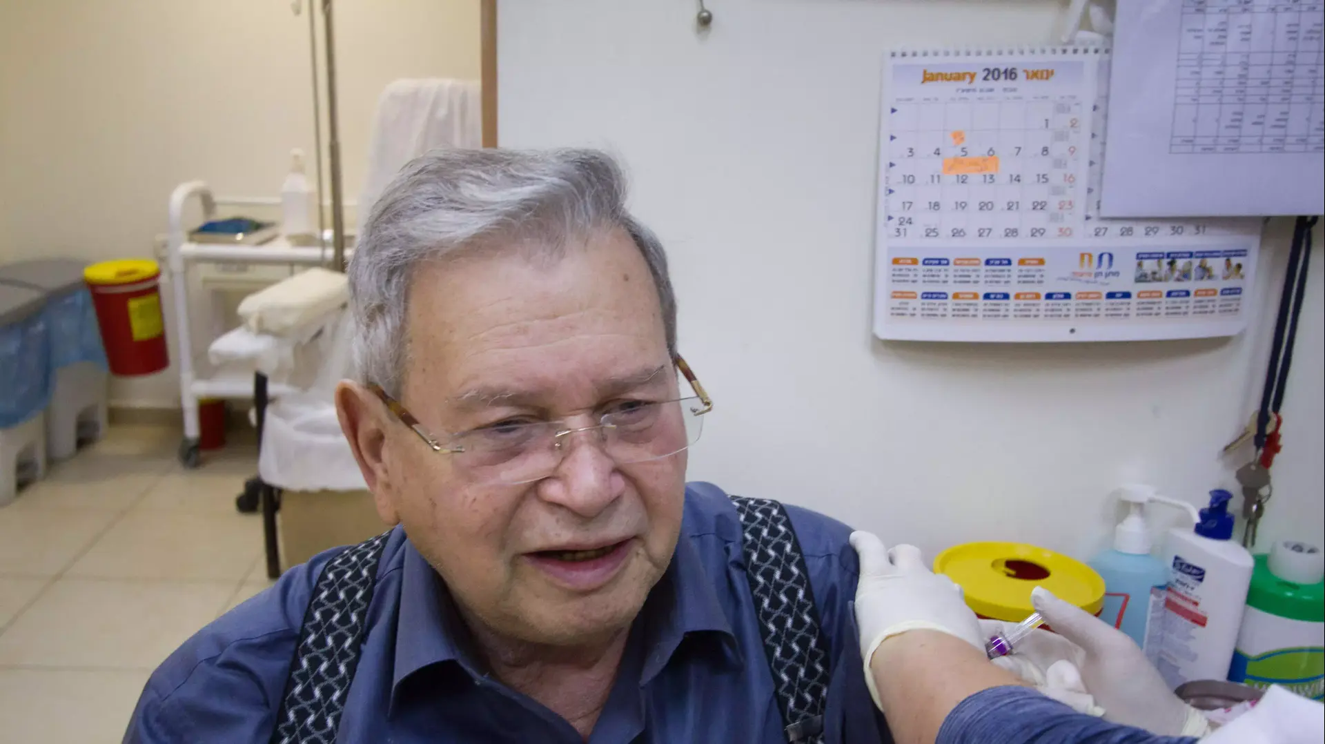אנשים מתחסנים לשפעת בסניף קופת חולים לאומית בתל אביב